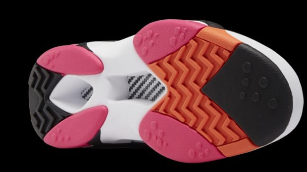 View of white, black, and orange Reebok sneaker outsole.